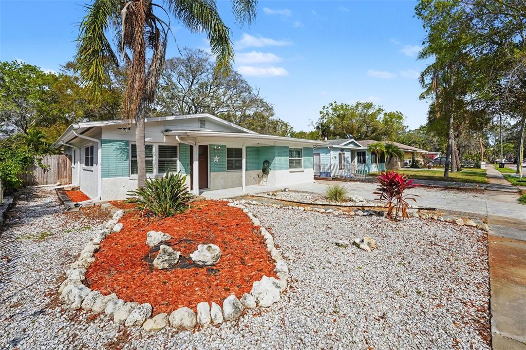 A single-story house with light blue siding, a gravel yard, and a palm tree — 318 BATH STREET, TARPON SPRINGS, FL