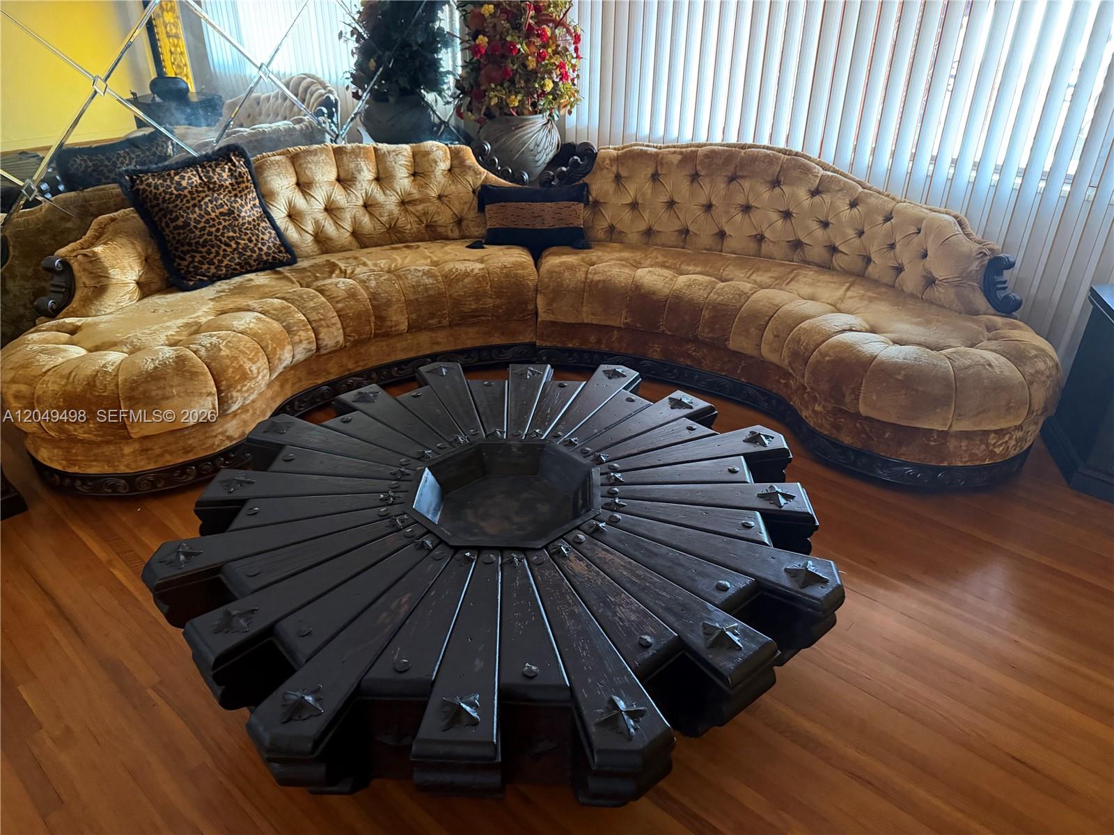 A curved, tufted gold velvet sofa sits before a large, circular dark wood coffee table — 291 W 59th St, Hialeah FL 33012, HIALEAH, FL