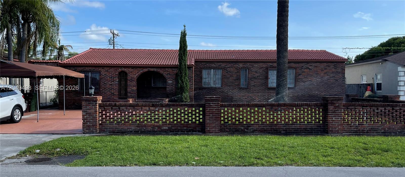 A single-story brick house features a red tile roof and a decorative brick perimeter fence — 291 W 59th St, Hialeah FL 33012, HIALEAH, FL