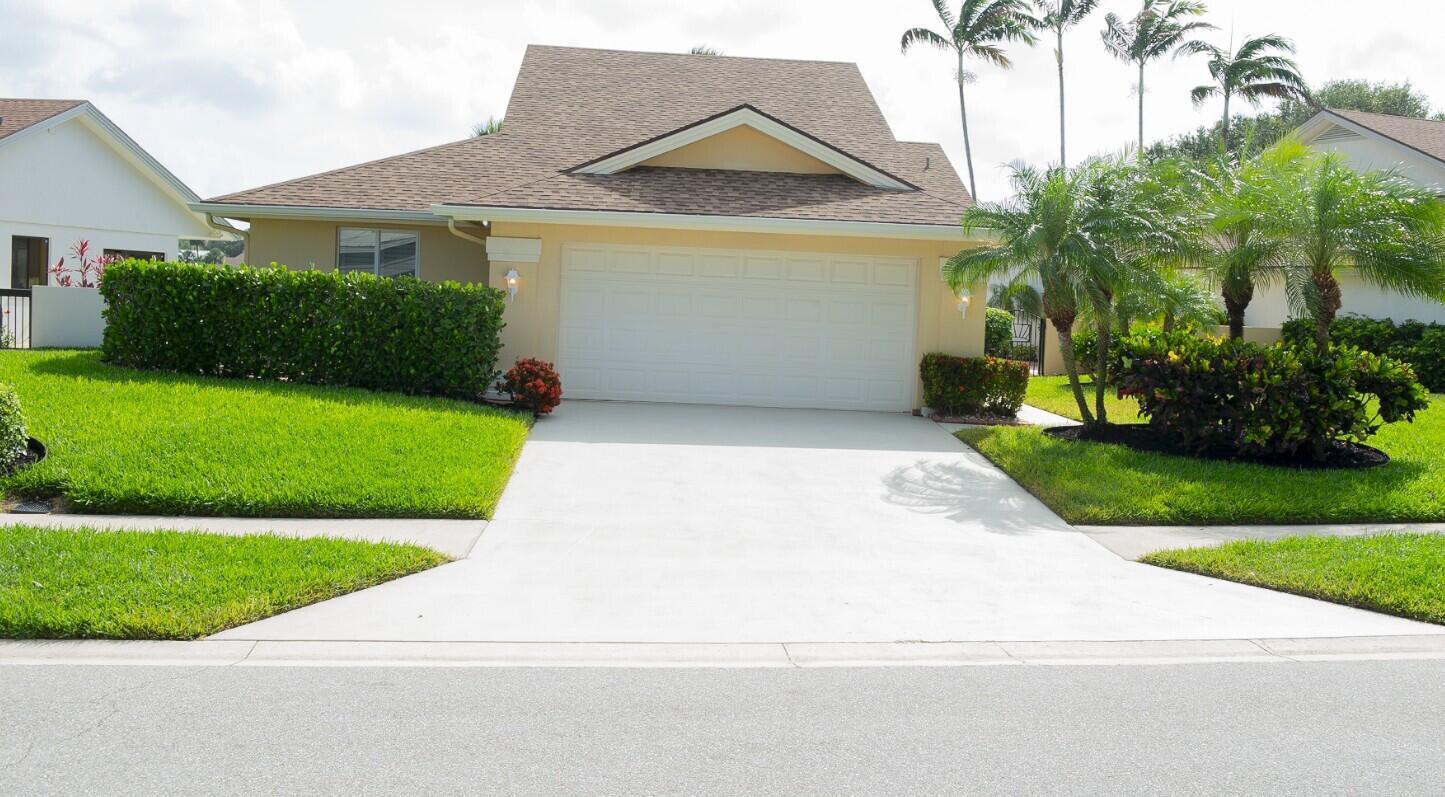 A single-story house with a beige exterior, a two-car garage, and a manicured front lawn — 114 Beach Summit Court, Jupiter FL 33477, JUPITER, FL