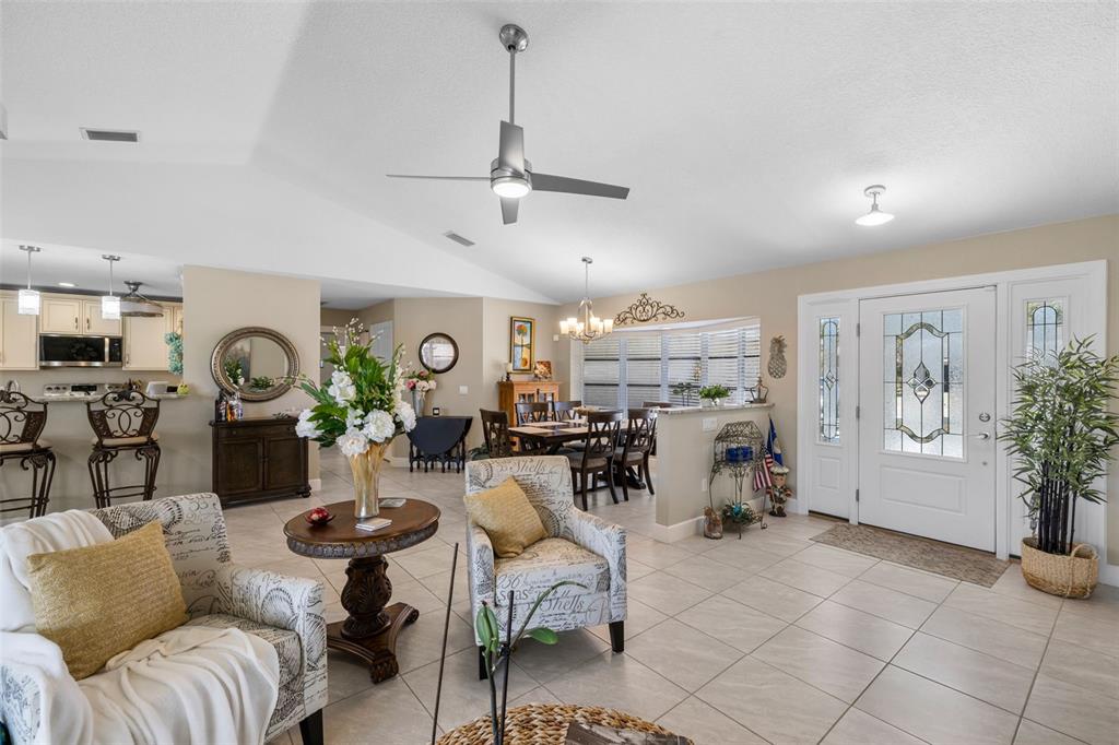 An open-concept living and dining area features tile flooring, a ceiling fan, and white trim — 26549 VALPARAISO DRIVE, PUNTA GORDA, FL