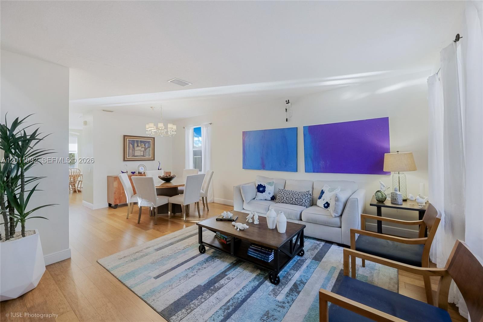 A living and dining area features hardwood floors, a striped rug, and blue wall art — 4394 Fox Ridge Dr, Weston FL 33331, WESTON, FL