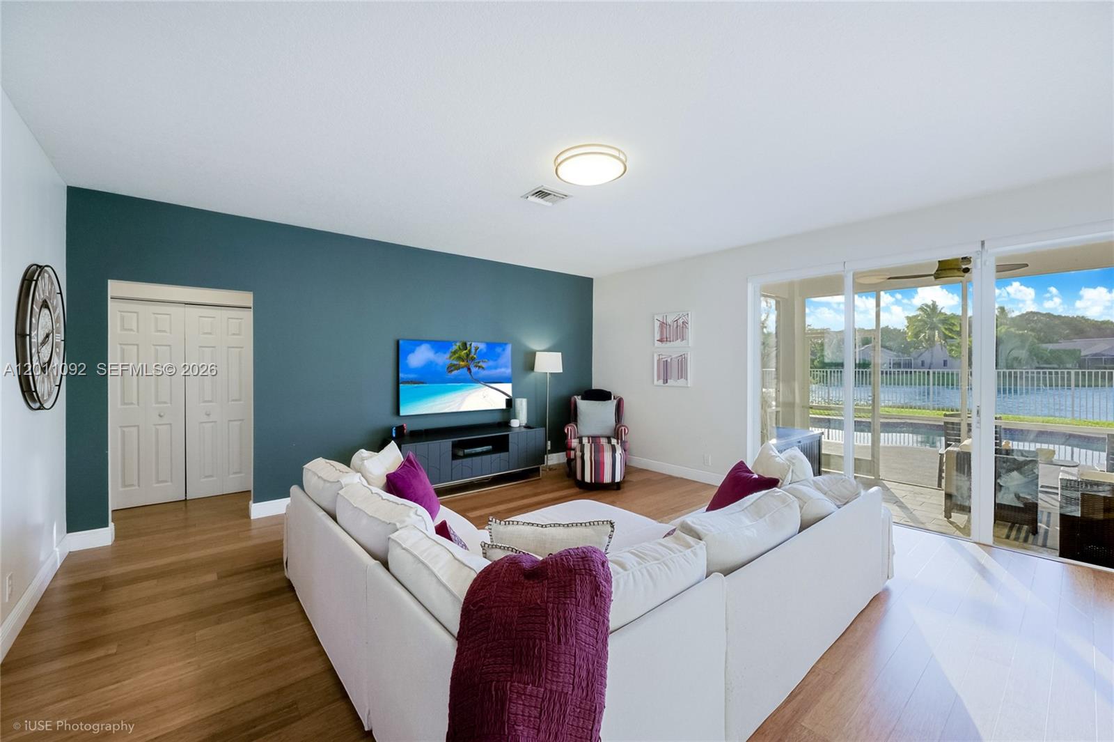 A living room features a white sectional sofa, a dark accent wall, and sliding glass doors — 4394 Fox Ridge Dr, Weston FL 33331, WESTON, FL