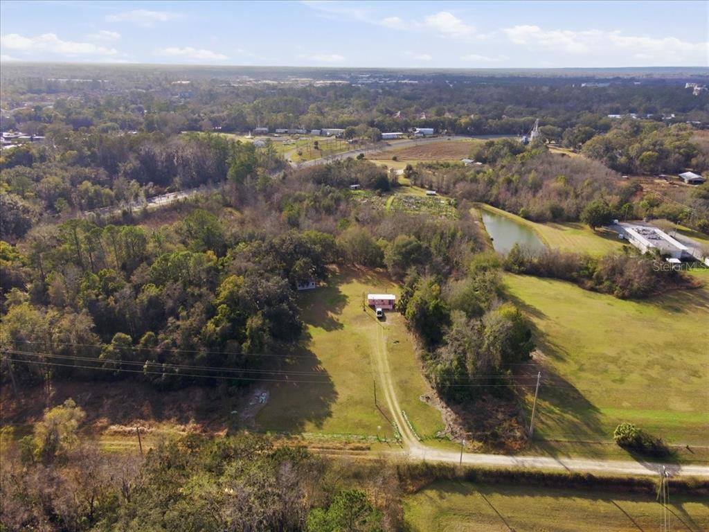 An aerial view shows a house situated on a large, grassy lot with trees — 2400 SW 23RD TERRACE, GAINESVILLE, FL