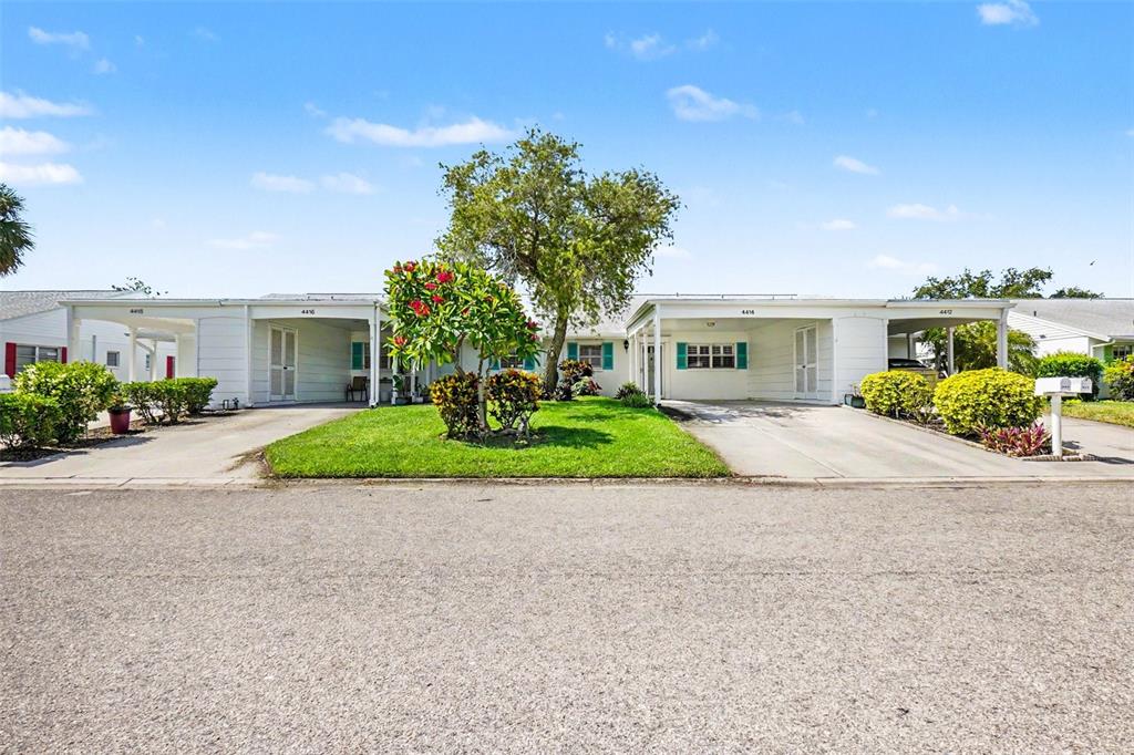 A concrete driveway leads to a covered carport entrance of a single-story residential building — 4414 MOUNT VERNON DRIVE UNIT 0, BRADENTON, FL
