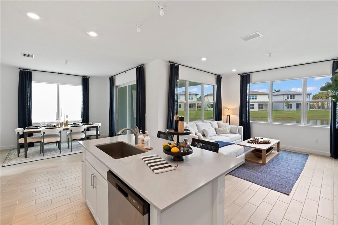 An open-concept kitchen, dining area, and living room with light tile floors and large windows — 22812 Caciano Road, Boca Raton FL 33433, BOCA RATON, FL
