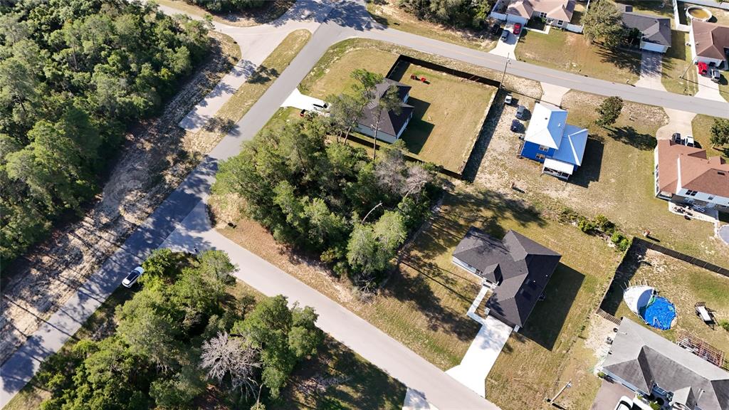 An aerial view shows several suburban homes, a wooded lot, and paved streets — TBD 127TH LANE ROAD, OCALA, FL