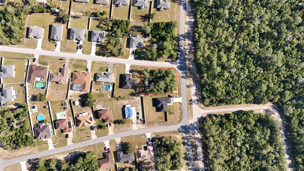 This aerial view shows a vacant, tree-covered residential lot outlined in red within a neighborhood — TBD 127TH LANE ROAD, OCALA, FL