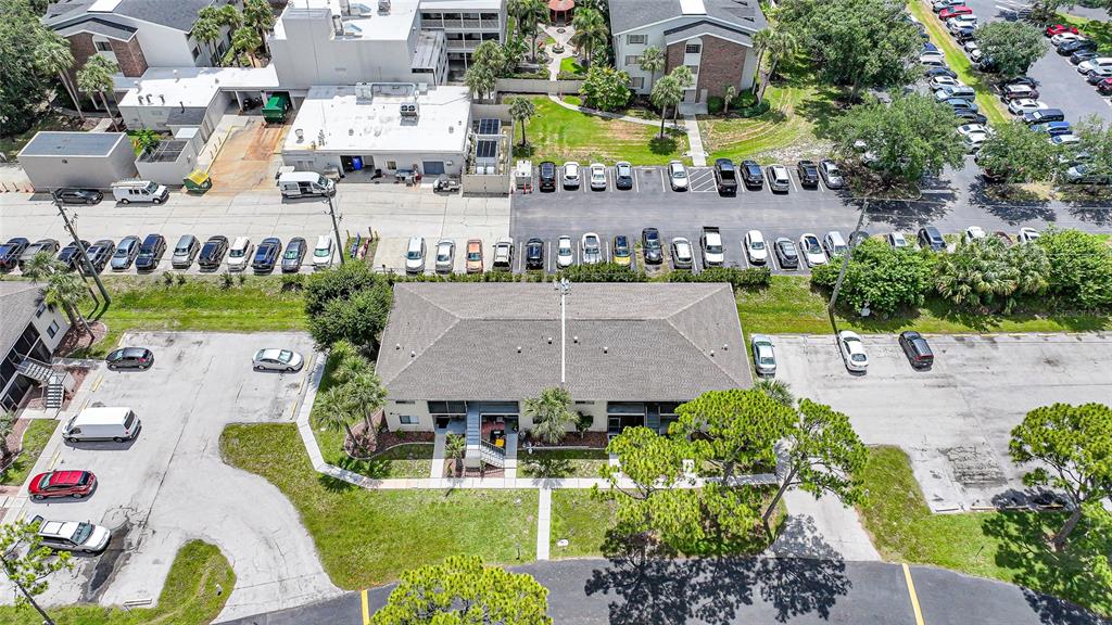 An aerial view shows a multi-story apartment building surrounded by parking lots and landscaping — 22523 WESTCHESTER BOULEVARD UNIT E203, PORT CHARLOTTE, FL