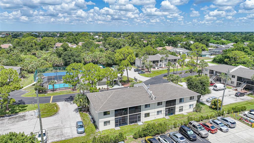 An aerial view shows a multi-story apartment building with a pool and parking lot — 22523 WESTCHESTER BOULEVARD UNIT E203, PORT CHARLOTTE, FL