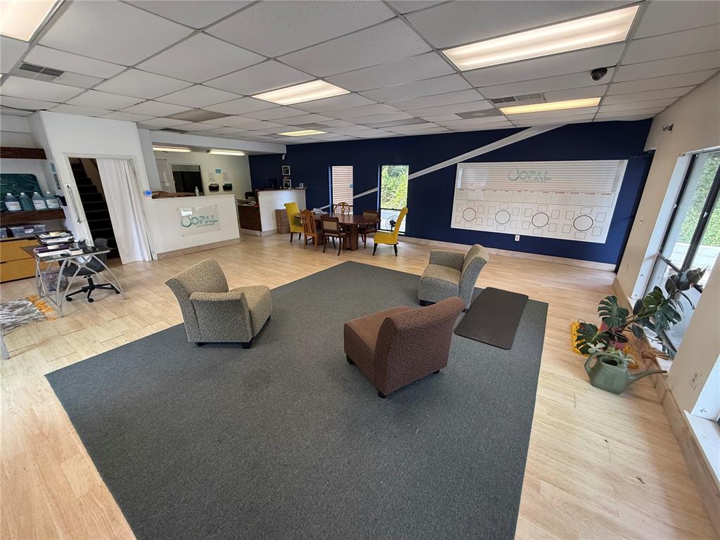 A commercial office space features a large area rug, seating, and a wall-mounted calendar — 3714 NW 97TH BOULEVARD, GAINESVILLE, FL
