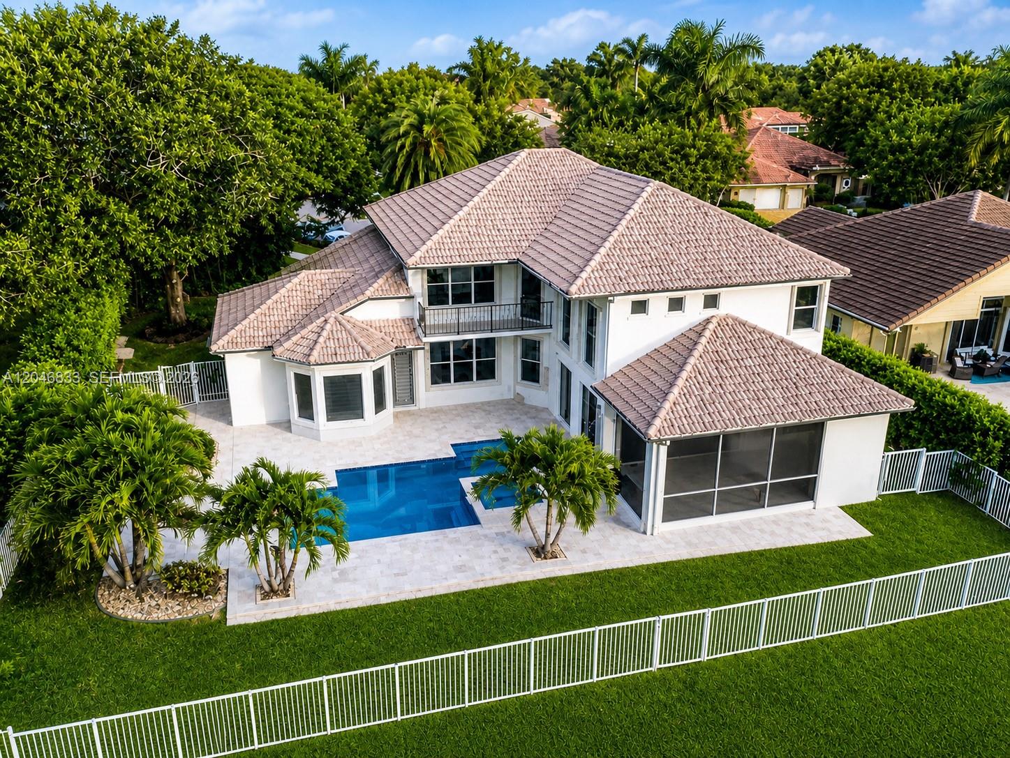 An aerial view of a two-story house with a pool, patio, and fenced backyard — 3683 W Lakes Estates Dr, Davie FL 33328, DAVIE, FL