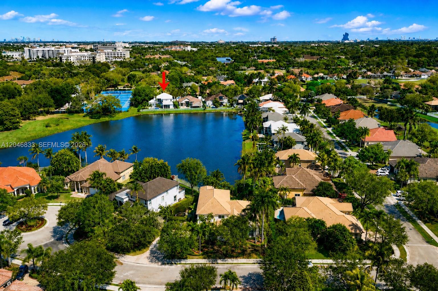 An aerial view shows a residential neighborhood with houses surrounding a central lake — 3683 W Lakes Estates Dr, Davie FL 33328, DAVIE, FL