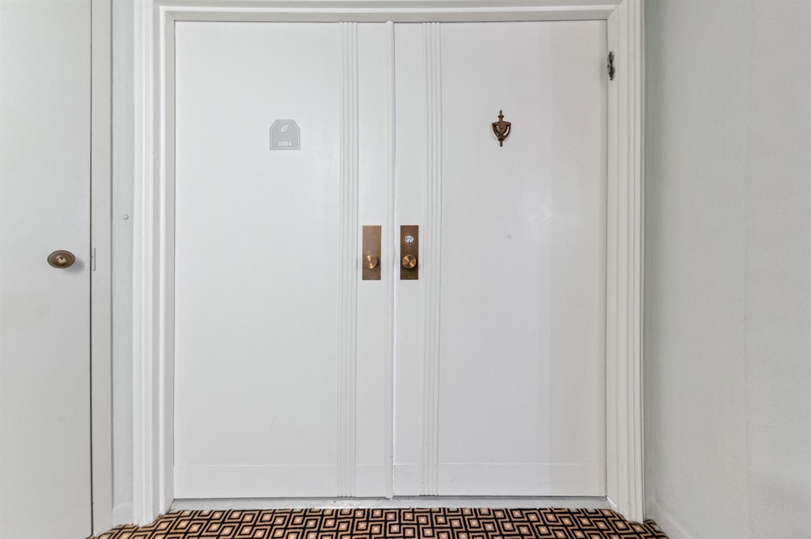 A pair of white double doors with brass hardware and a door knocker — 1900 Consulate Place # 1004, West Palm Beach FL 33401, WEST PALM BEACH, FL