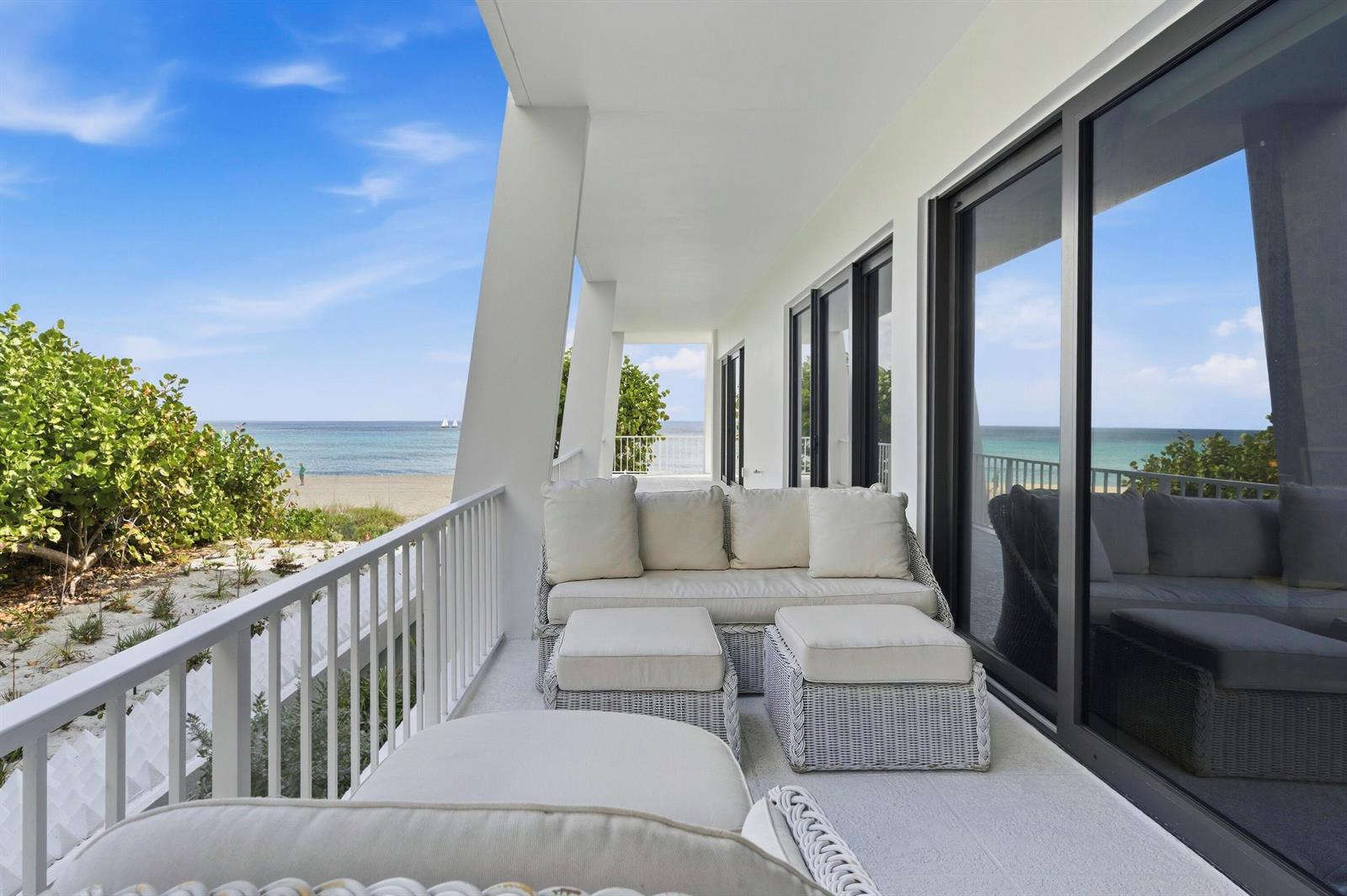 A balcony with white wicker furniture overlooks a sandy beach and the ocean — 2275 S Ocean Boulevard # 207n, Palm Beach FL 33480, PALM BEACH, FL