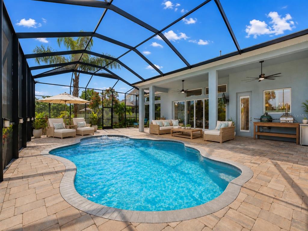 A screened-in patio features a swimming pool, outdoor furniture, and a covered seating area — 1310 LOREA LANE, BRANDON, FL