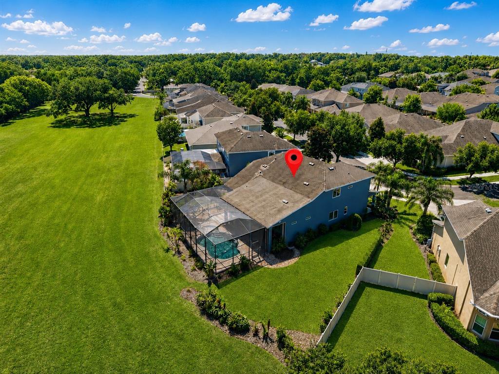 An aerial view shows a blue two-story house with a screened pool and large backyard — 1310 LOREA LANE, BRANDON, FL