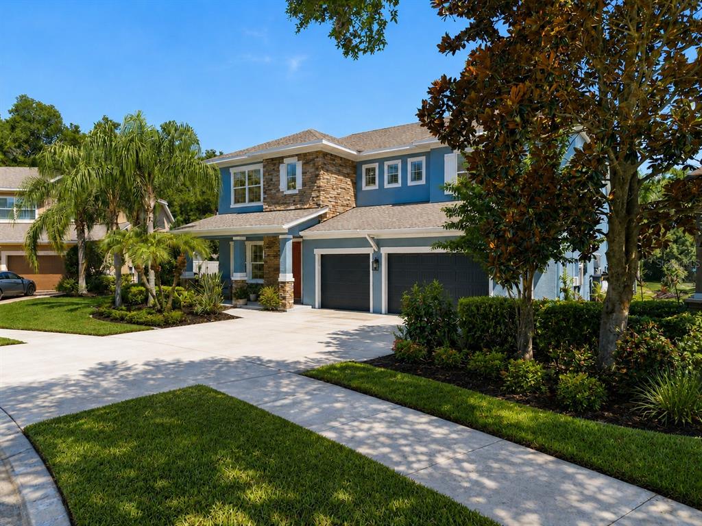 A two-story blue house with a stone facade, a two-car garage, and a concrete driveway — 1310 LOREA LANE, BRANDON, FL