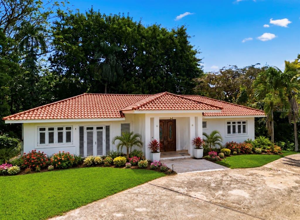 A single-story house with a red tile roof, white exterior, and a paved driveway — 7 VANDA, GUAYNABO, PR