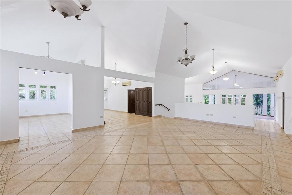 A spacious, open-concept living area features vaulted ceilings, tile flooring, and multiple hanging light fixtures — 7 VANDA, GUAYNABO, PR