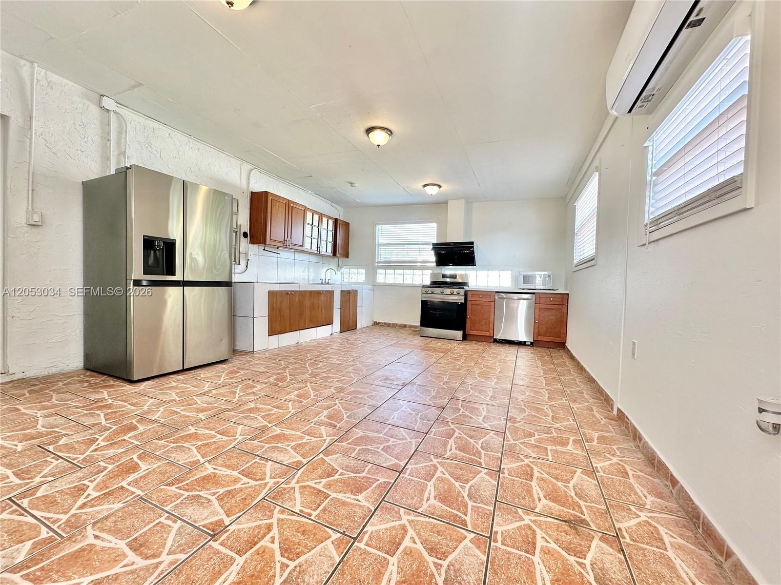 A kitchen features stainless steel appliances, wood cabinets, and patterned tile flooring — 12021 SW 191st St # 2, Miami FL 33177, MIAMI, FL