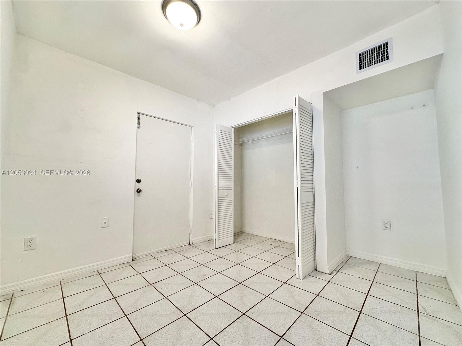 A room with white walls, white tile flooring, a closet, and a single door — 12021 SW 191st St # 2, Miami FL 33177, MIAMI, FL