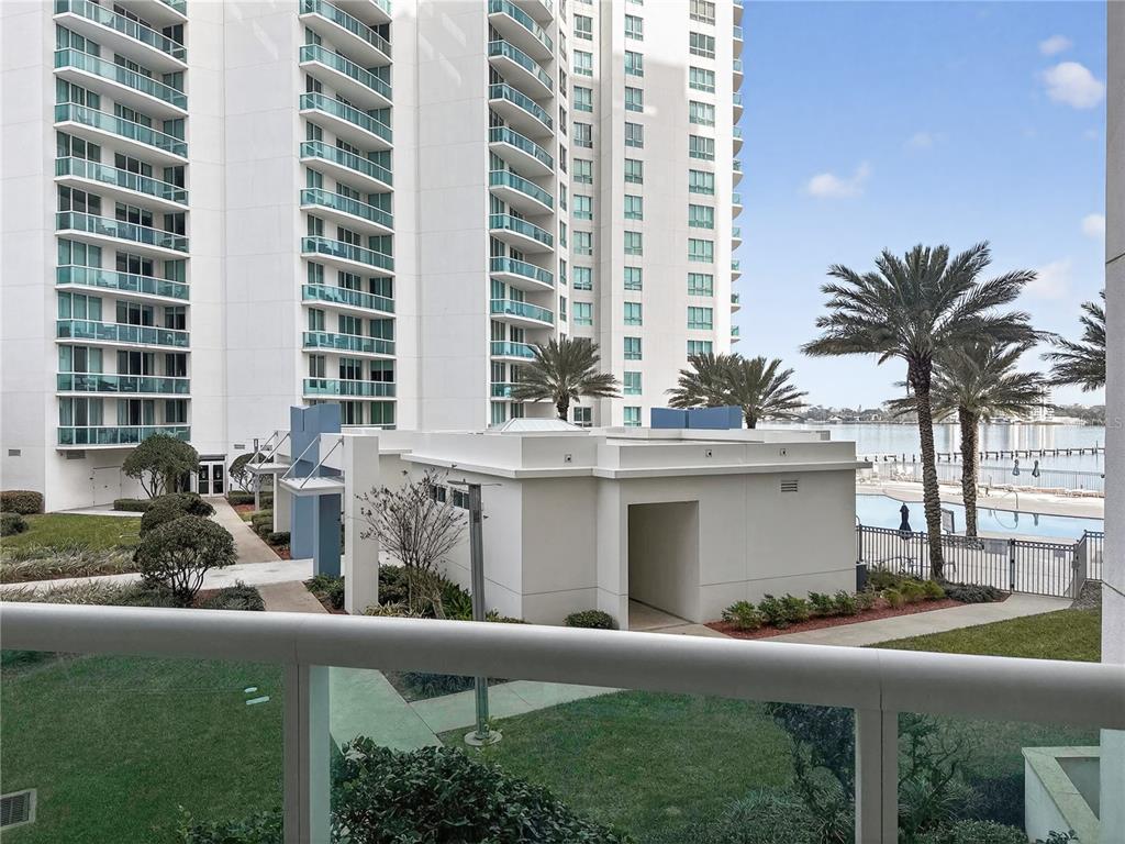 A view from a balcony overlooking a courtyard, a small building, and a waterfront pool — 231 RIVERSIDE DRIVE UNIT 208-1, HOLLY HILL, FL