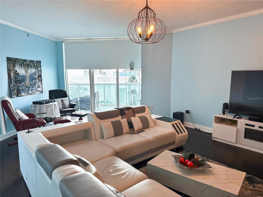 A living room features a large white sectional sofa, a television, and light blue walls — 231 RIVERSIDE DRIVE UNIT 208-1, HOLLY HILL, FL