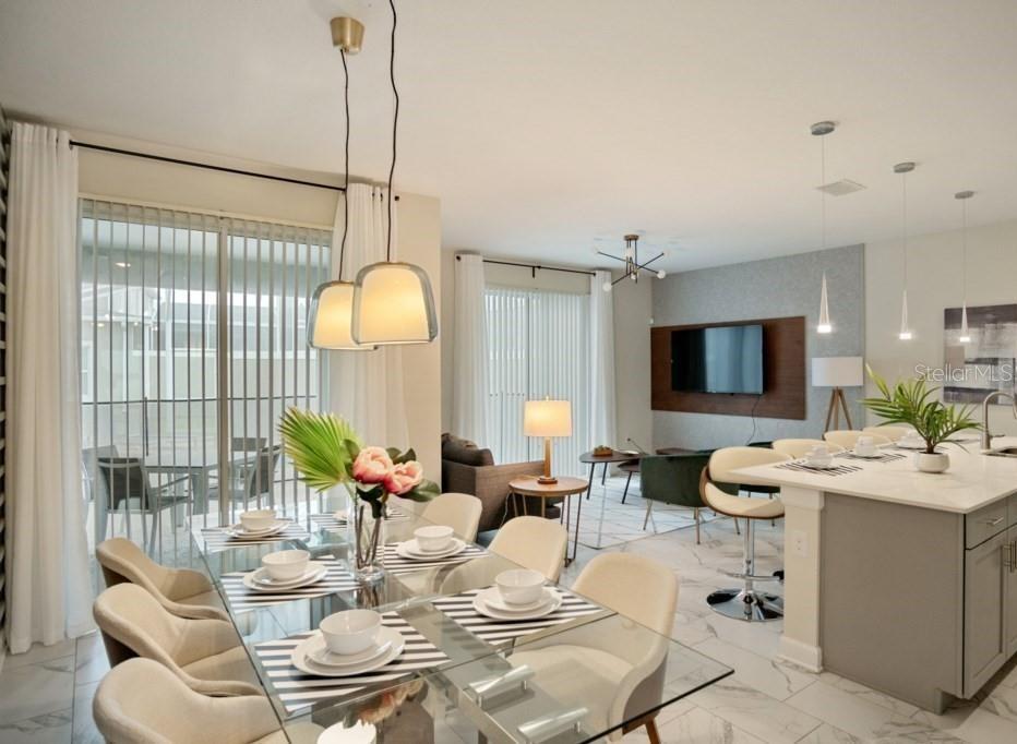 An open-concept dining and living area features a glass table, marble floors, and modern lighting — 468 OCEAN COURSE AVENUE, DAVENPORT, FL