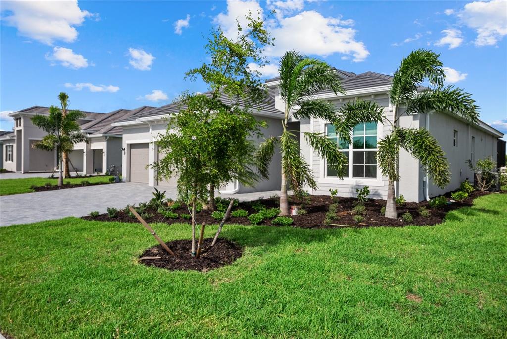 A single-story house with a gray exterior, a paved driveway, and palm trees in the yard — 5918 MOUND KEY RUN, LAKEWOOD RANCH, FL