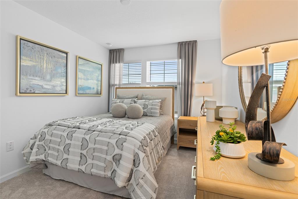 A bedroom features a bed with patterned bedding, two framed artworks, and a wooden dresser — 3864 SE 36TH LANE, OCALA, FL