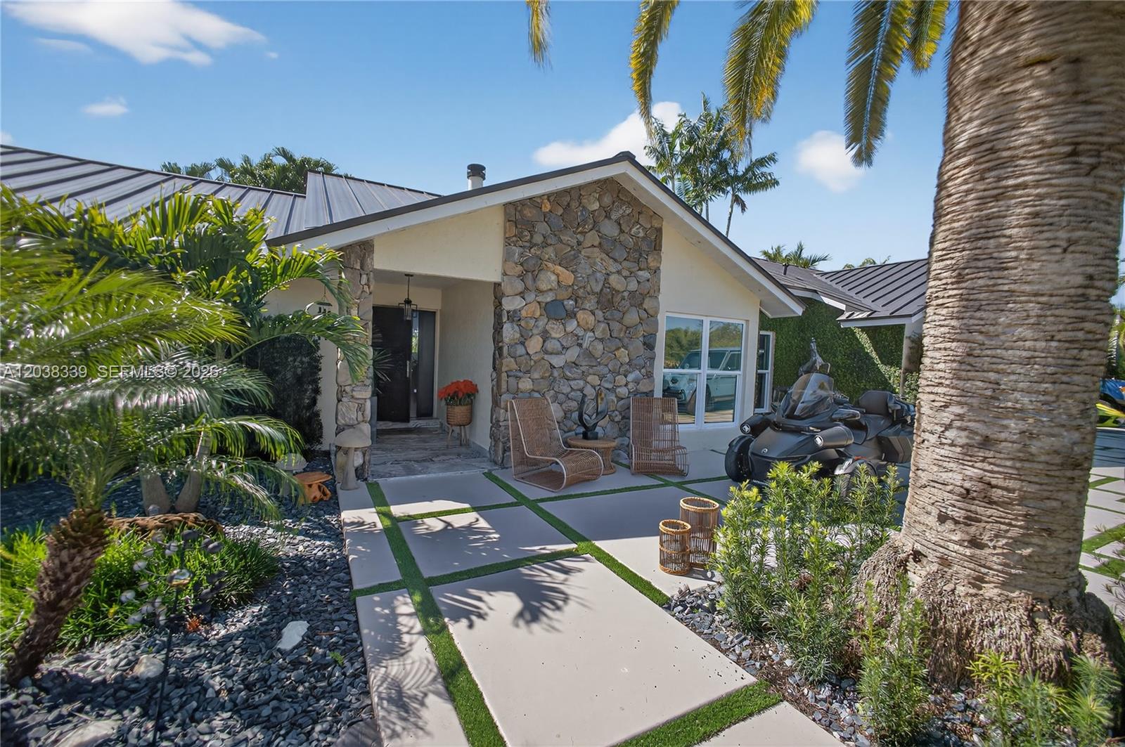 A stone-accented house exterior features a concrete paver walkway and a parked three-wheeled motorcycle — 15050 SW 167th St, Miami FL 33187, MIAMI, FL
