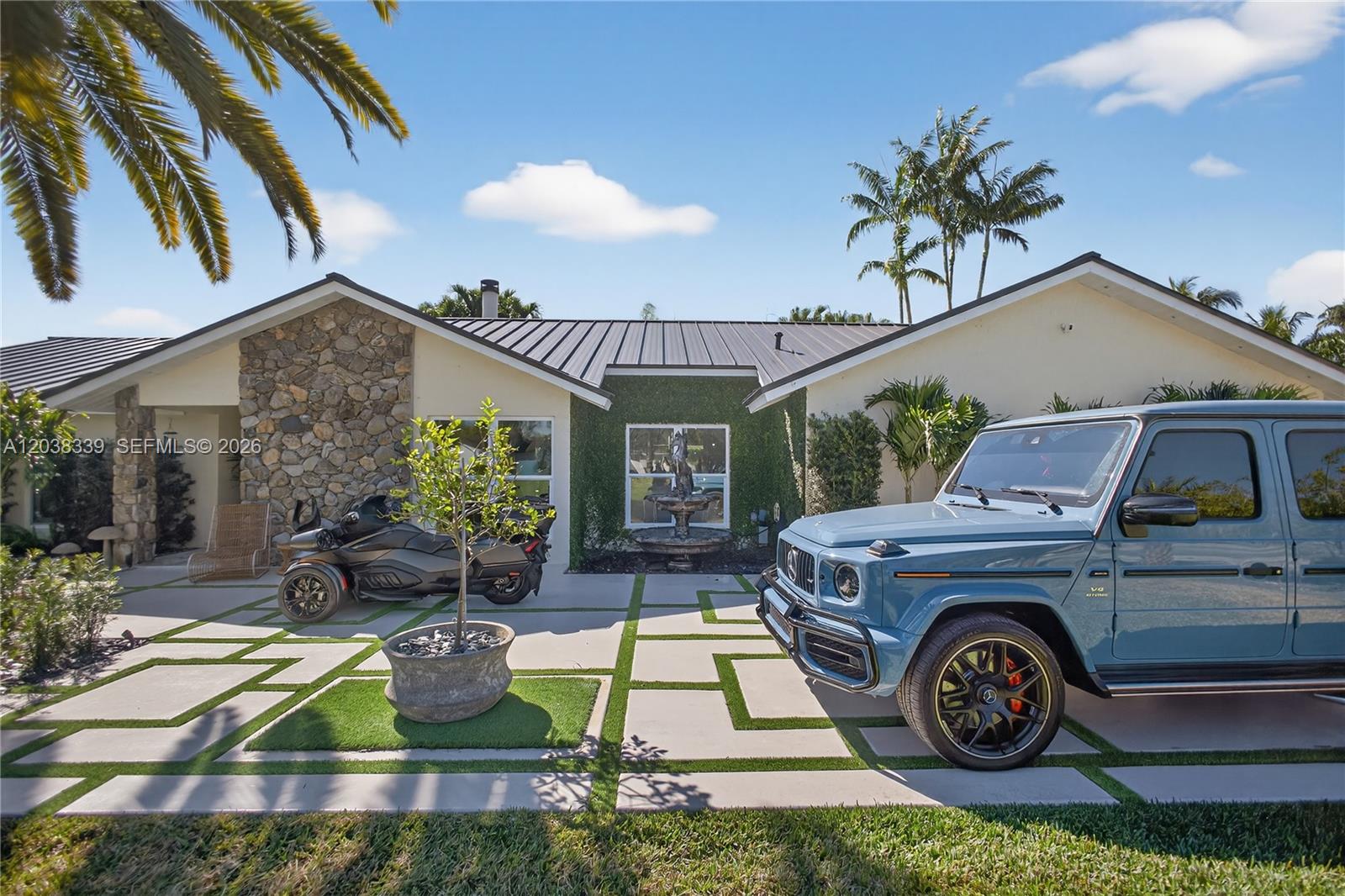 A blue SUV and a three-wheeled motorcycle are parked on a paved driveway before a house — 15050 SW 167th St, Miami FL 33187, MIAMI, FL