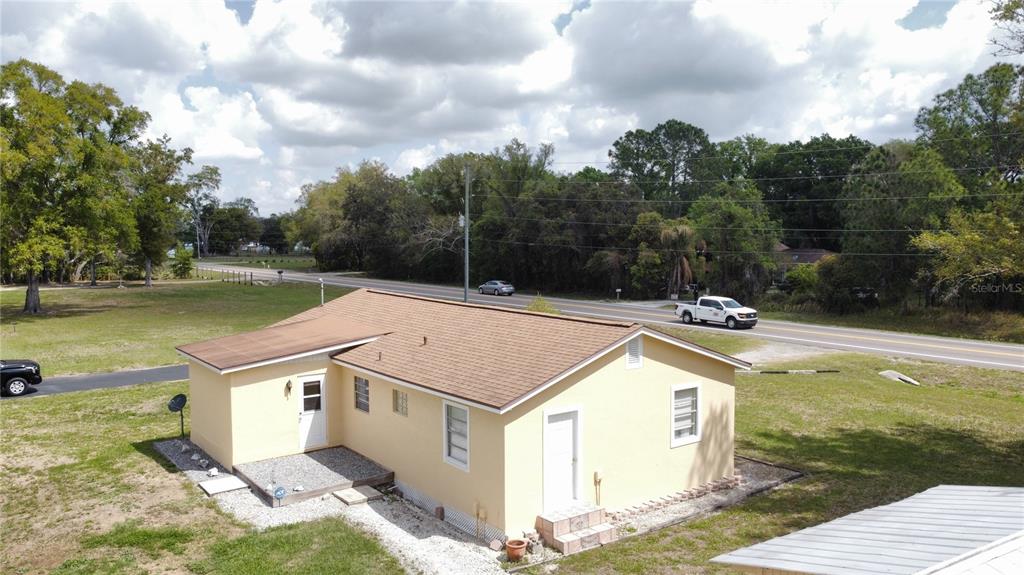 An aerial view shows a yellow, single-story house with a brown roof near a road — 2305 STATE ROAD 33 HIGHWAY, CLERMONT, FL