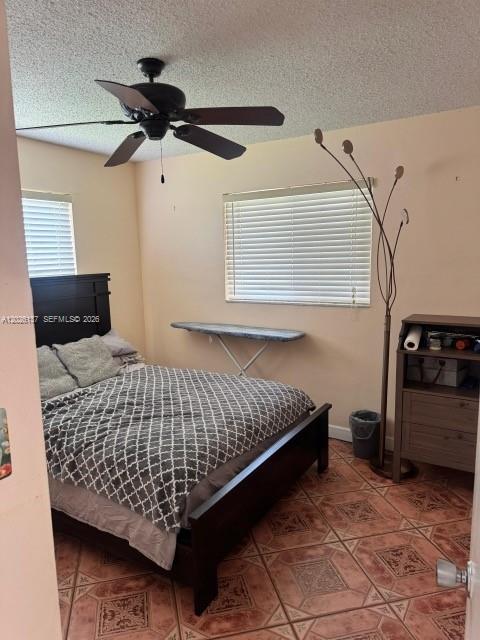 A bedroom features a dark wood bed frame, a ceiling fan, and tiled flooring — 5403 NW 27th Ave, Tamarac FL 33309, TAMARAC, FL