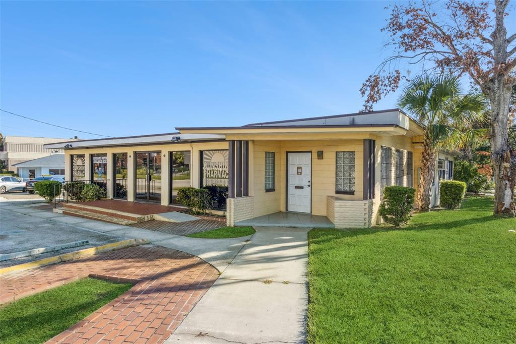 A single-story commercial building with yellow siding, a flat roof, and a brick walkway — 1231 LAKELAND HILLS BOULEVARD, LAKELAND, FL