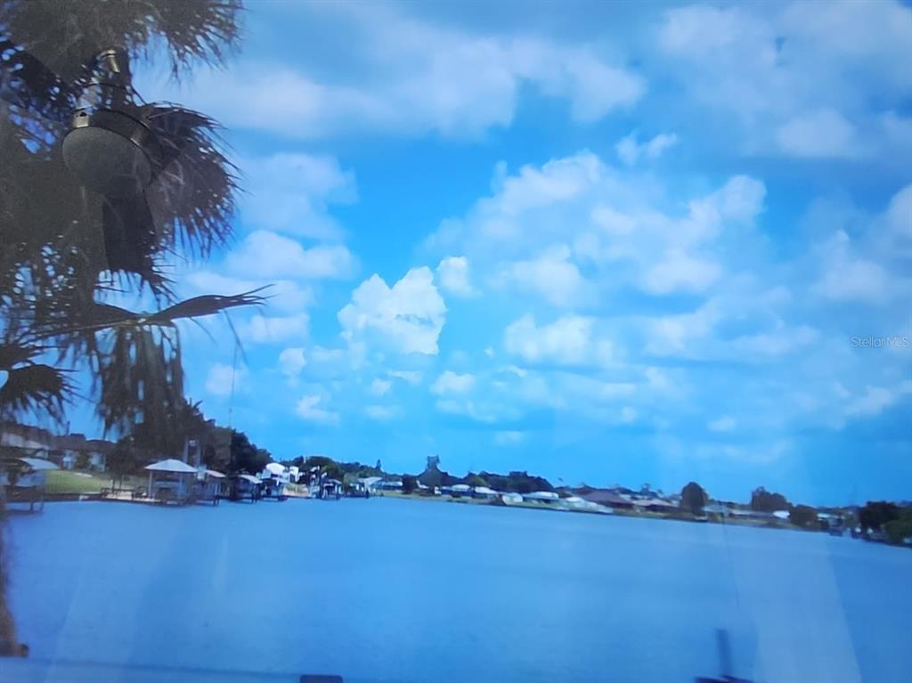 A view of a lake with houses along the shore under a blue sky — 267 CAPATOLA STREET, PORT CHARLOTTE, FL