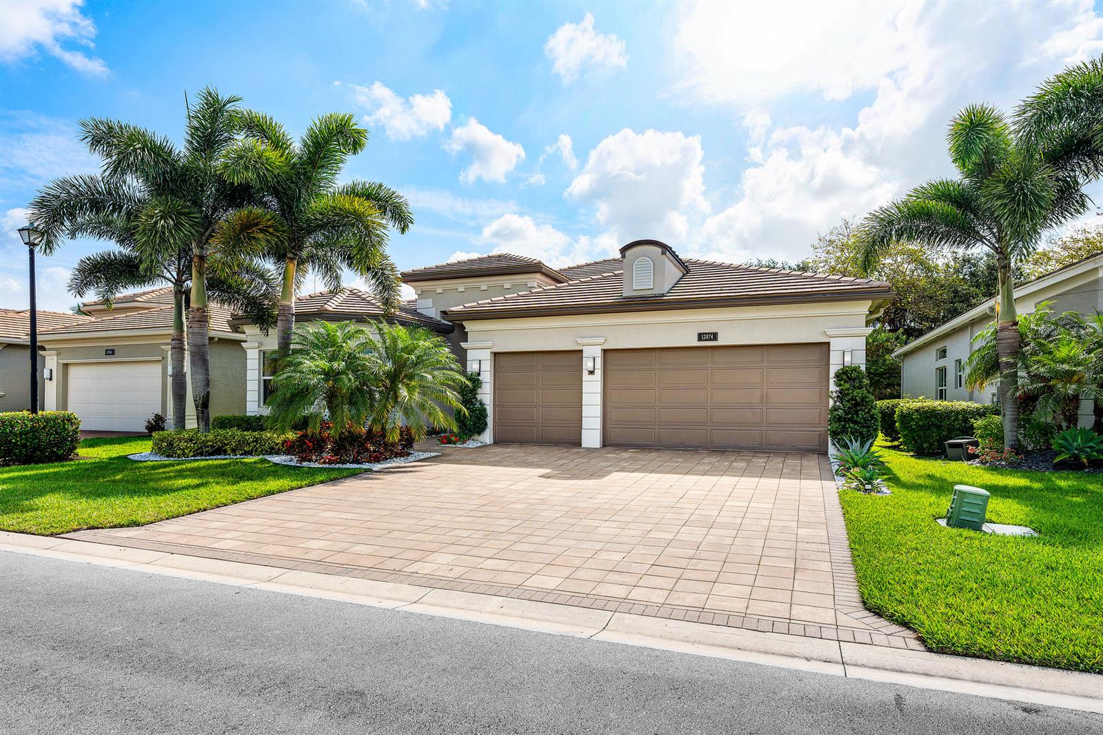 A single-story house with a paved driveway, a three-car garage, and palm trees — 12874 Granite Mountain Pass, Boynton Beach FL 33473, BOYNTON BEACH, FL