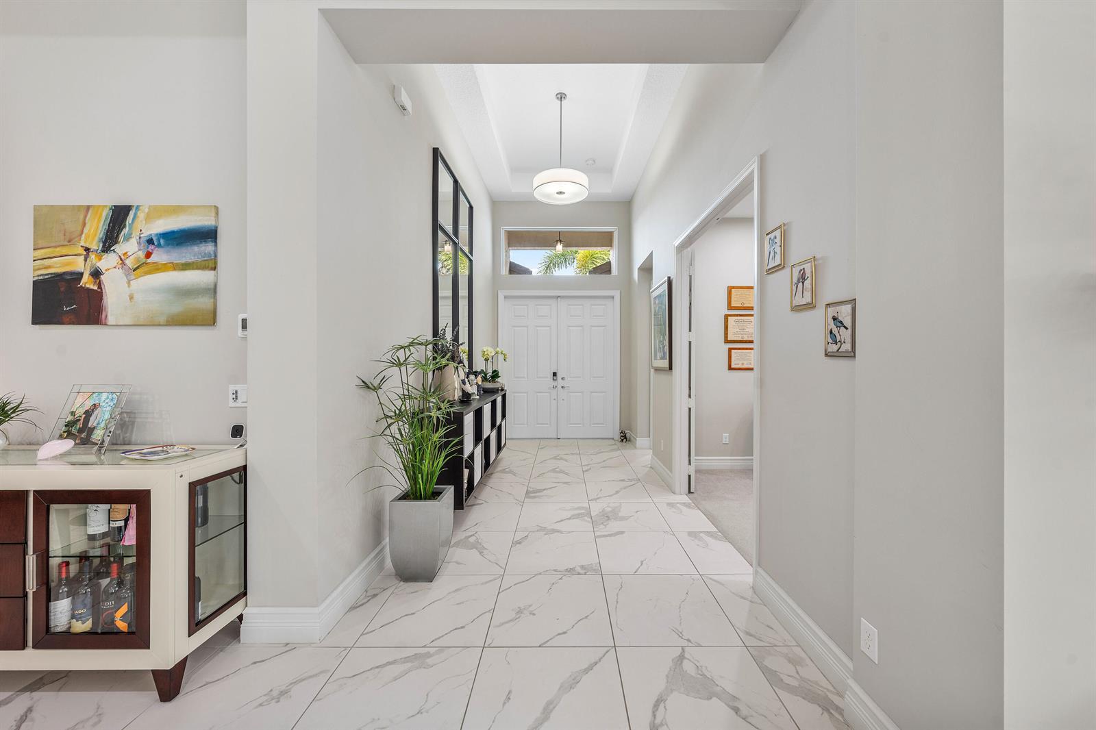 A bright entryway features white marble-look tile flooring, a double-door entrance, and a pendant light — 12874 Granite Mountain Pass, Boynton Beach FL 33473, BOYNTON BEACH, FL