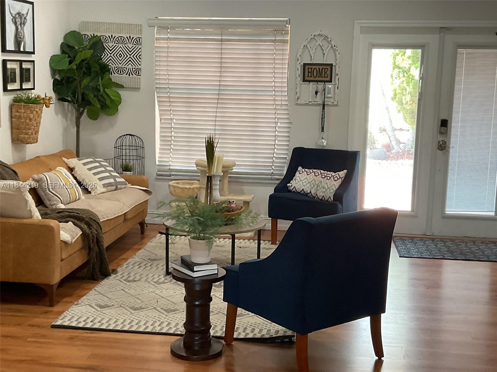 A living room features a blue armchair, a tan sofa, and a round coffee table — 8453 NW 189 Street Rd, Hialeah FL 33015, HIALEAH, FL