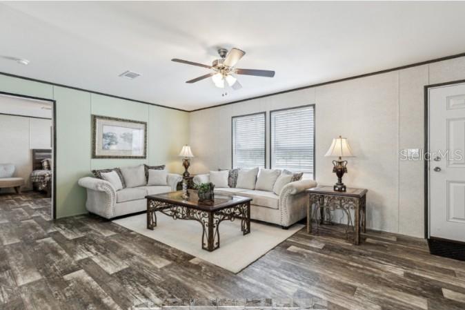 A living room with light-colored sofas, a coffee table, and wood-look flooring — 27760 BERMONT ROAD, PUNTA GORDA, FL