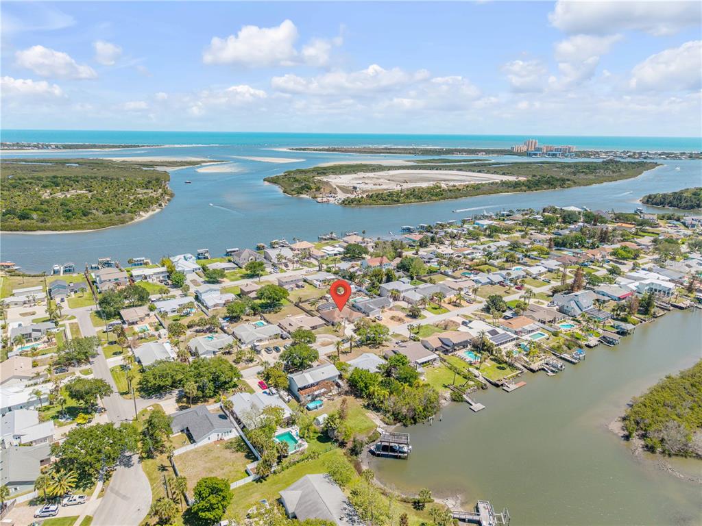 This aerial view shows a residential neighborhood situated along a coastal waterway — 10 CUNNINGHAM DRIVE, NEW SMYRNA BEACH, FL