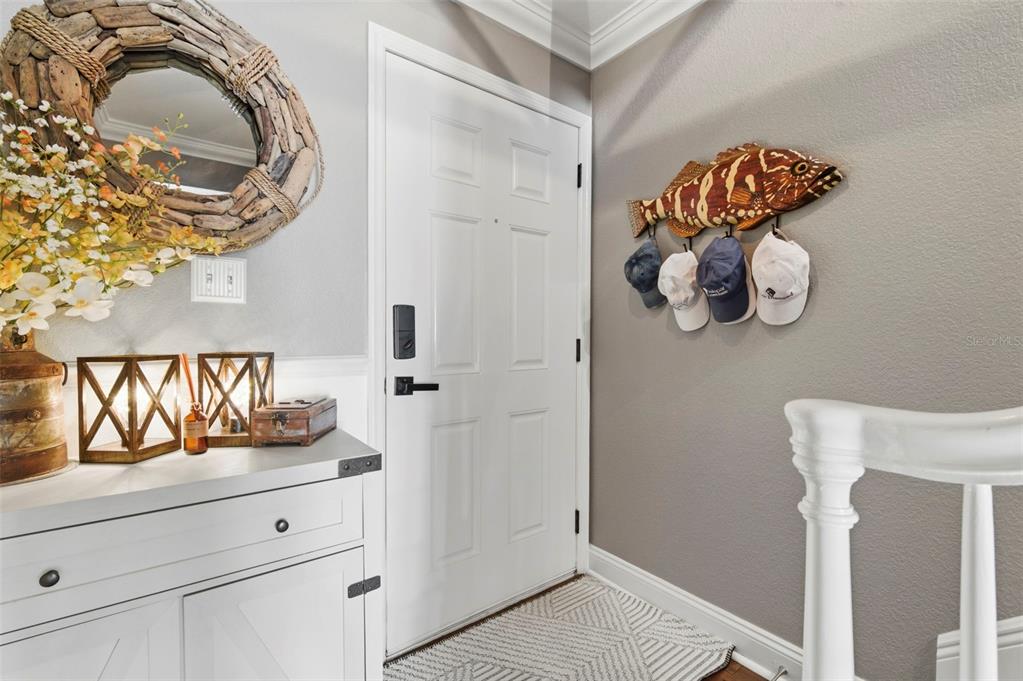 An entryway features a white door, a fish-shaped wall rack with hats, and a console table — 4751 COQUINA KEY DRIVE SE, ST PETERSBURG, FL