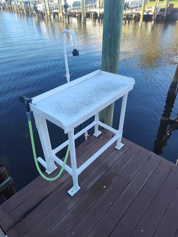 A white PVC fish cleaning station stands on a wooden dock overlooking a canal — 127ss COQUINA KEY DR SE DRIVE, ST PETERSBURG, FL