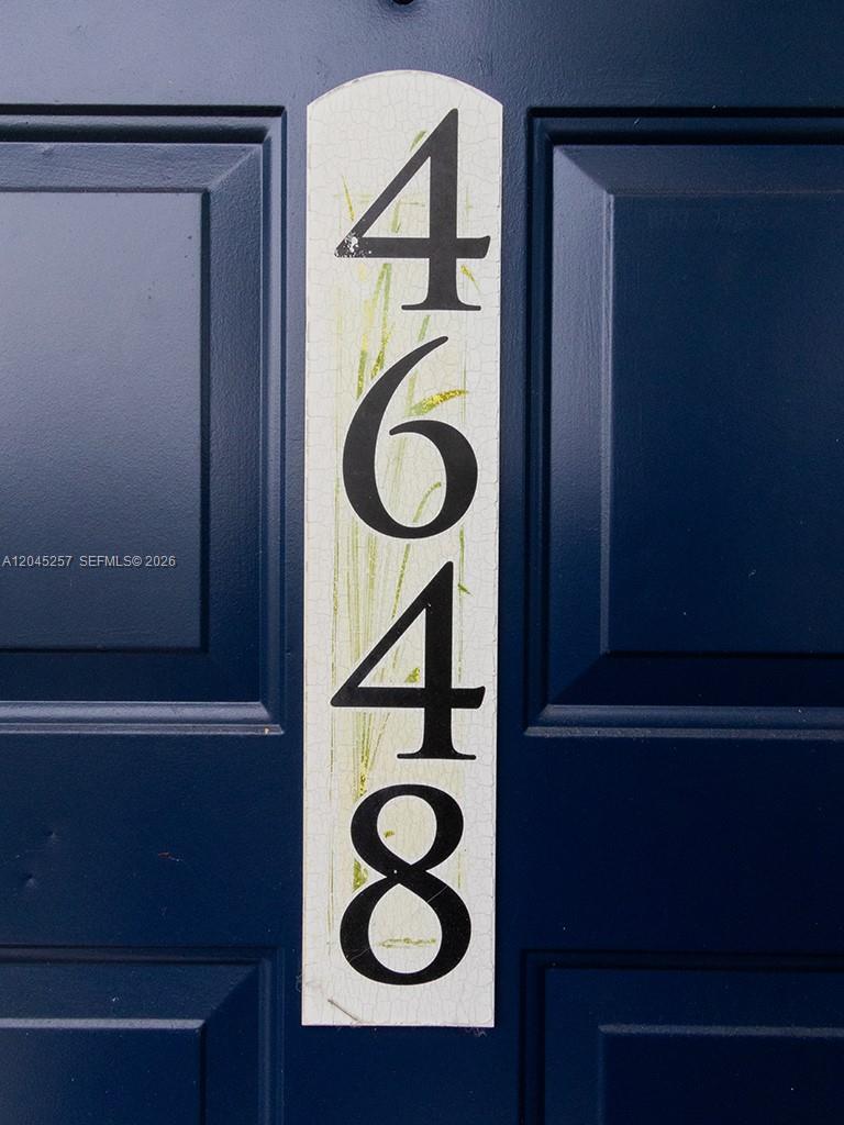 A vertical white address plaque with the number 4648 is mounted on a blue door — 4648 NW 9th Dr # 4648, Plantation FL 33317, PLANTATION, FL