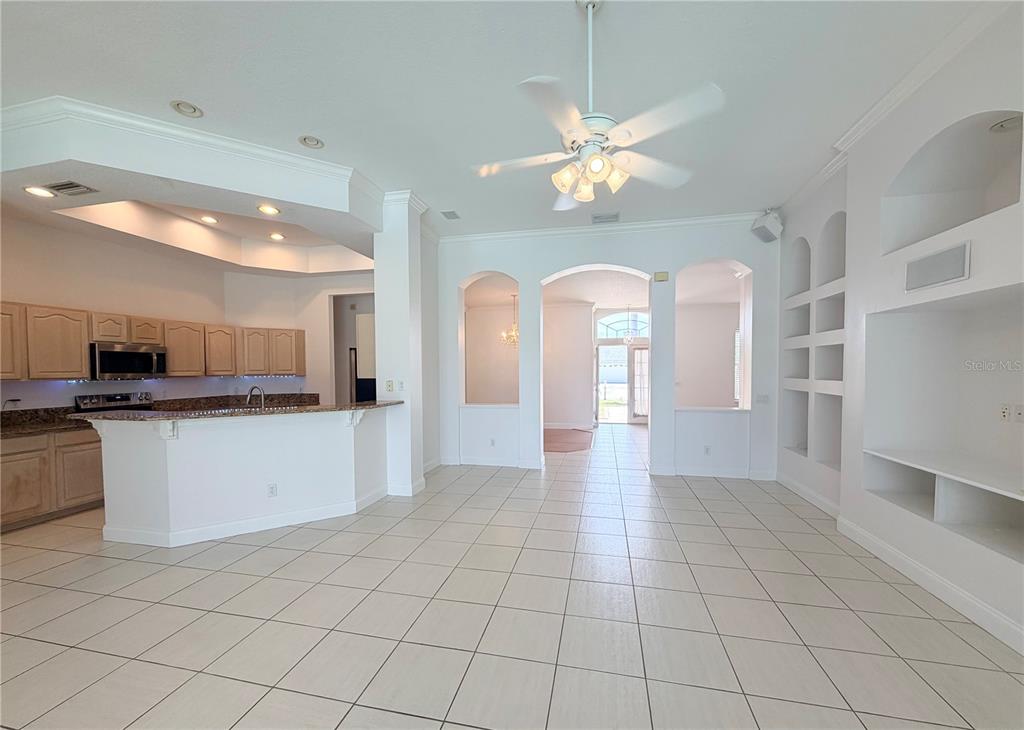 A spacious room features light tile flooring, a kitchen with granite countertops, and arched doorways — 442 KNIGHT DRIVE, TARPON SPRINGS, FL
