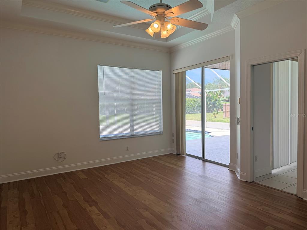 A room with wood-look flooring, a ceiling fan, a large window, and sliding glass doors — 442 KNIGHT DRIVE, TARPON SPRINGS, FL