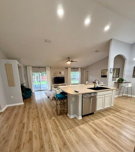 An open-concept kitchen with a central island overlooks a living area with wood-look flooring — 15 POINSETTIA LANE, PALM COAST, FL