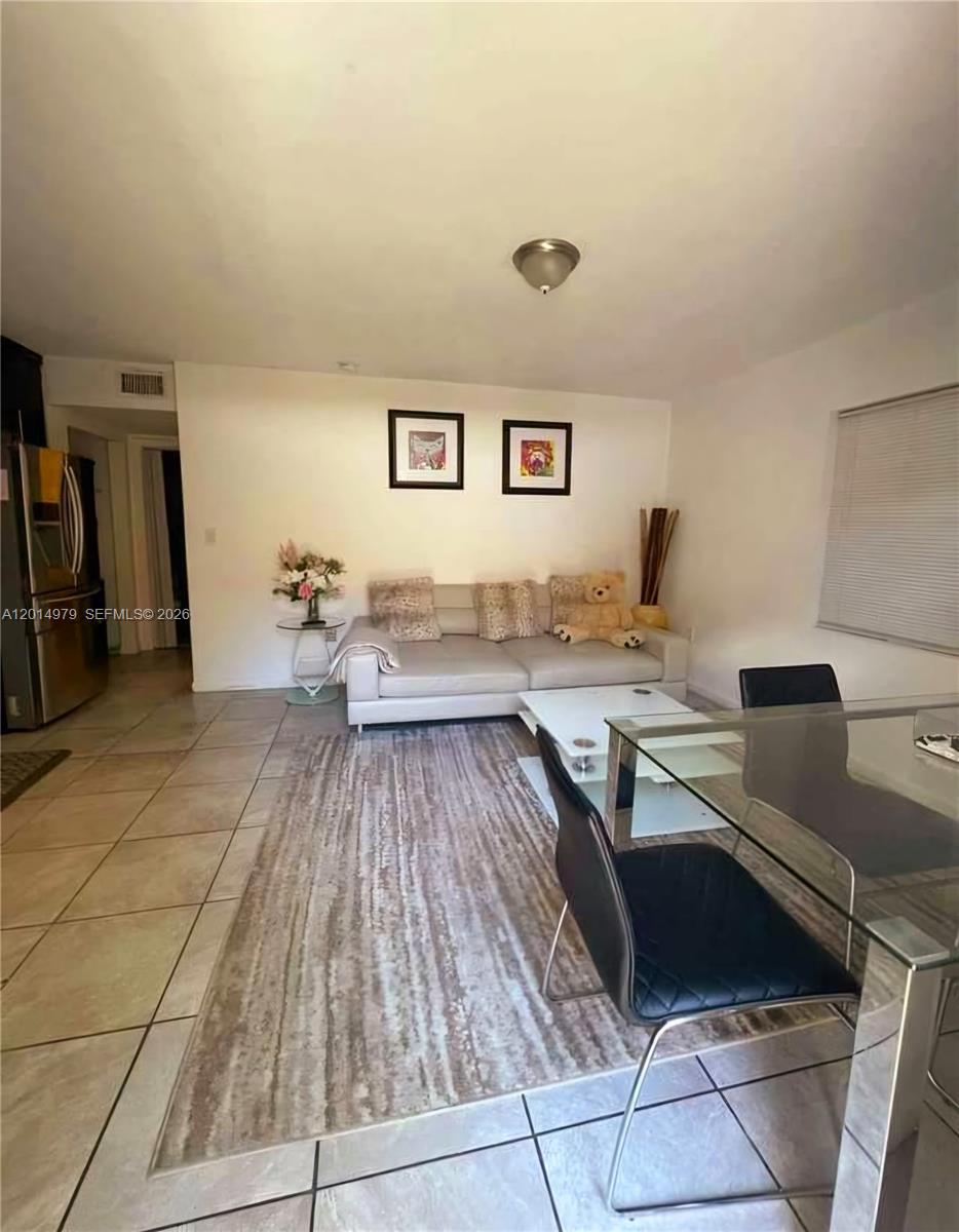 A living room with tile floors, a light-colored sofa, and a glass dining table — 315 NW 59th St # 2, Miami FL 33127, MIAMI, FL