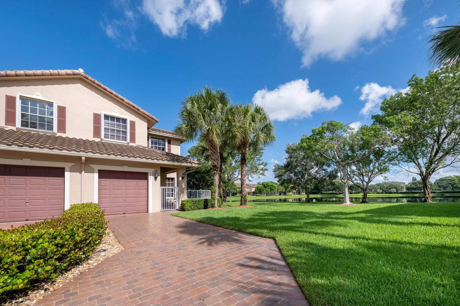 A two-story house with a brick driveway, two garage doors, and a large grassy yard — 3501 Lakeside Drive, Davie FL 33328, DAVIE, FL